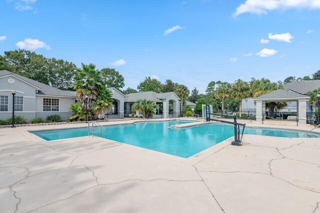 community pool with fence and a patio area