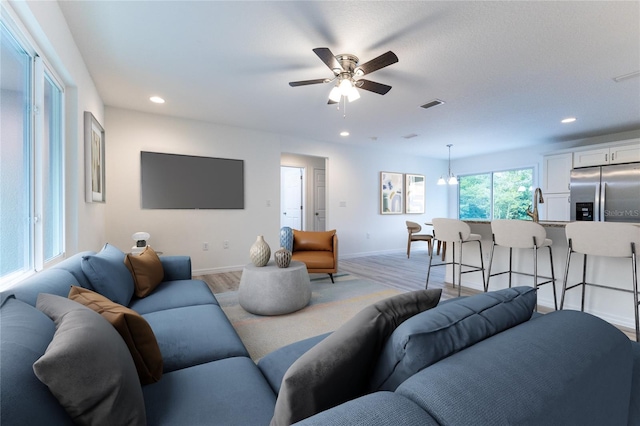 living room with ceiling fan and light hardwood / wood-style floors