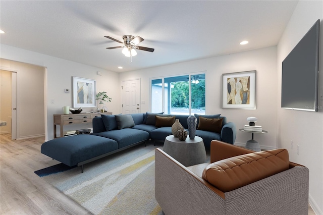 living room featuring ceiling fan and light hardwood / wood-style flooring