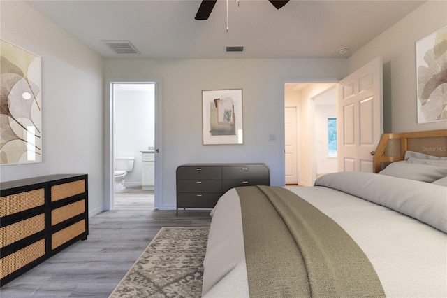 bedroom with ceiling fan, ensuite bath, and hardwood / wood-style floors