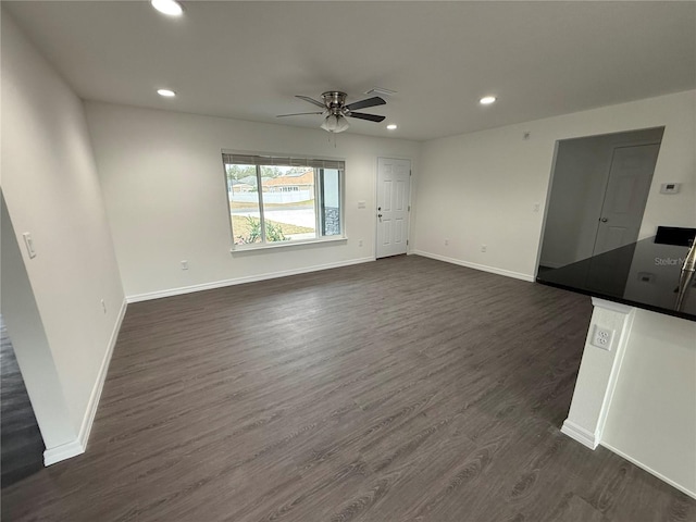 unfurnished living room featuring ceiling fan and dark hardwood / wood-style floors