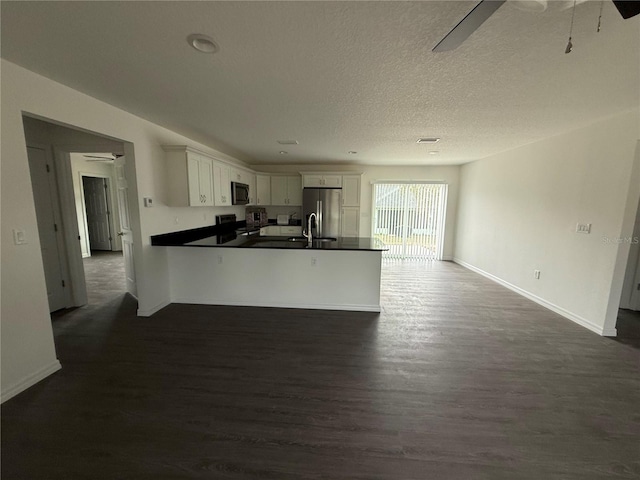 kitchen with dark hardwood / wood-style floors, stove, kitchen peninsula, white cabinetry, and stainless steel fridge with ice dispenser