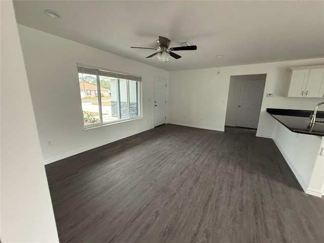 unfurnished living room featuring ceiling fan and dark hardwood / wood-style floors