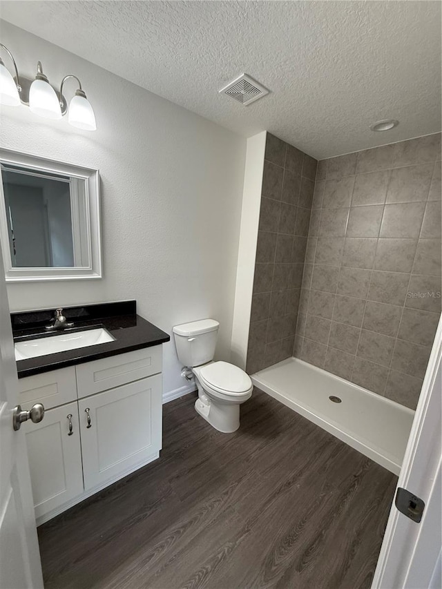 bathroom featuring hardwood / wood-style floors, toilet, vanity, and a textured ceiling