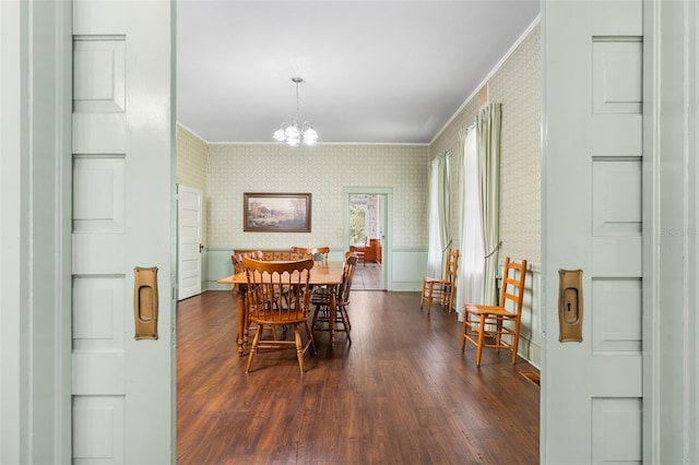 dining space featuring ornamental molding, dark wood-type flooring, and an inviting chandelier