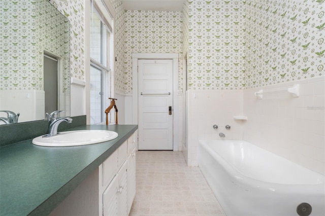 bathroom featuring tile walls, vanity, and a bathing tub