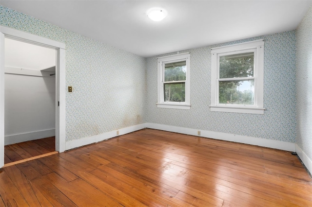 unfurnished bedroom with a closet, hardwood / wood-style floors, and a walk in closet