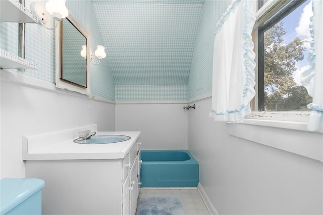 bathroom with vanity, a bathing tub, and toilet