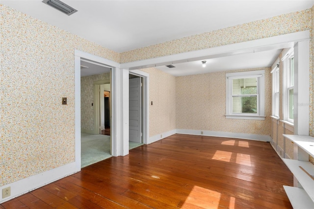 26502 NW 3rd Ave, Newberry, FL 32669 - empty room featuring wood-type flooring, baseboards, wallpapered walls, and visible vents