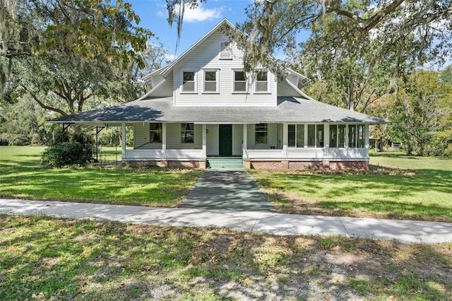 farmhouse-style home featuring a sunroom, covered porch, and a front yard