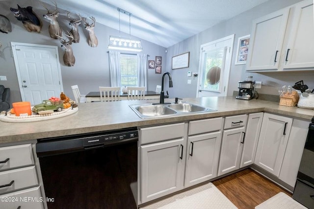 kitchen featuring pendant lighting, black dishwasher, sink, lofted ceiling, and white cabinets