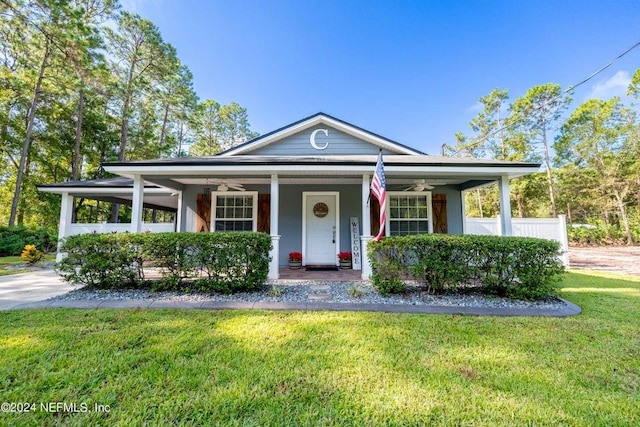 view of front of property featuring ceiling fan, a front lawn, and covered porch