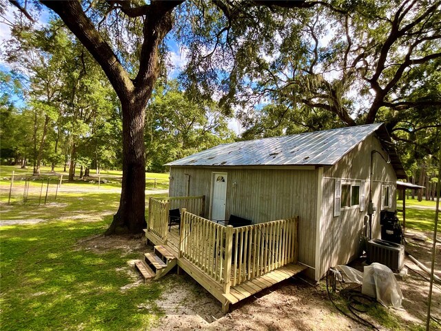 view of outdoor structure with a yard and central air condition unit