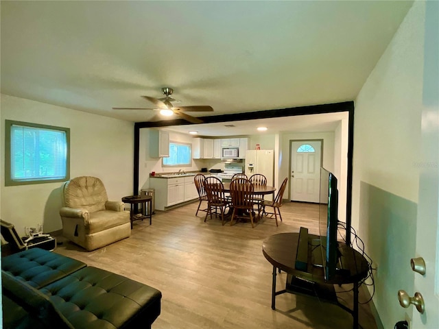 living room featuring ceiling fan, sink, and light hardwood / wood-style flooring