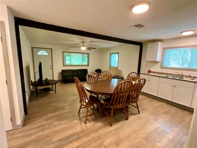 dining room featuring light wood-type flooring, ceiling fan, and sink