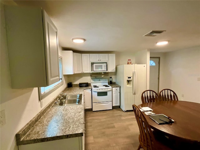 kitchen featuring light wood-type flooring, sink, white appliances, and white cabinetry