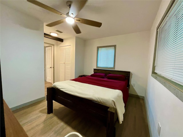 bedroom featuring multiple windows, ceiling fan, and hardwood / wood-style floors