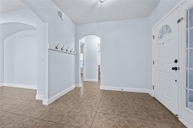 tiled foyer with a textured ceiling