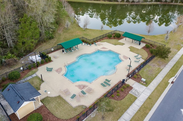 view of swimming pool featuring a patio, a yard, and a water view