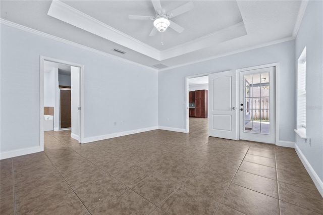 tiled spare room with crown molding, a raised ceiling, and ceiling fan