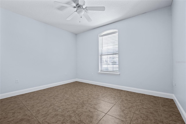 empty room with tile patterned floors, a textured ceiling, and ceiling fan