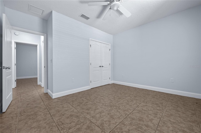 tiled spare room with ceiling fan and a textured ceiling