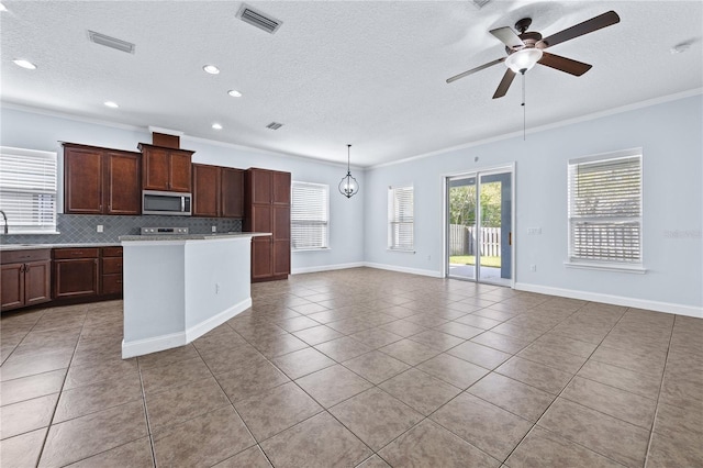 kitchen with tasteful backsplash, hanging light fixtures, ceiling fan, light tile patterned floors, and crown molding