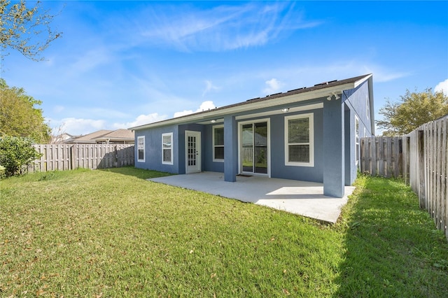 back of house with a patio and a lawn