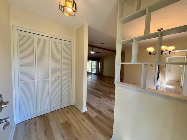 hallway with hardwood / wood-style flooring and a chandelier