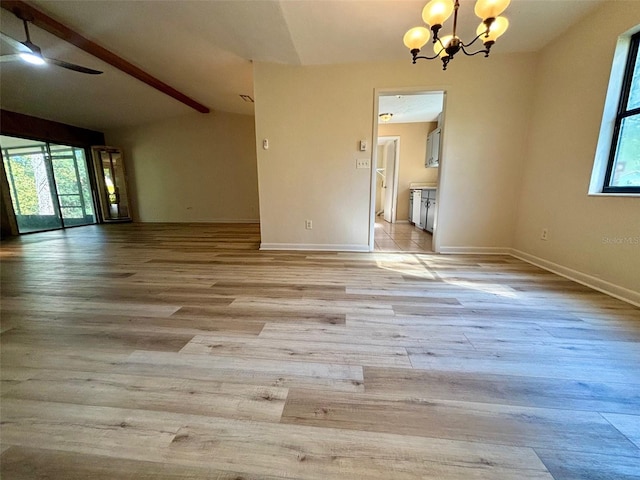 unfurnished room featuring ceiling fan with notable chandelier, lofted ceiling with beams, and light hardwood / wood-style flooring