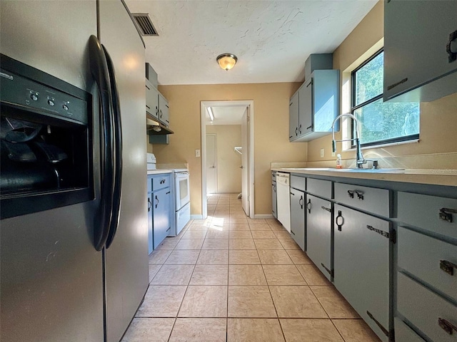 kitchen featuring light tile patterned flooring, sink, a textured ceiling, and white appliances