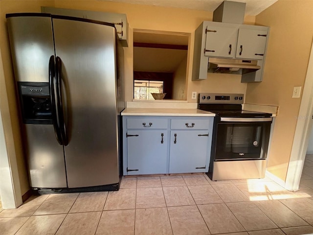 kitchen featuring stainless steel appliances, light tile patterned floors, and white cabinets