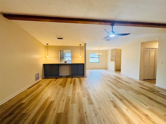 unfurnished living room featuring ceiling fan with notable chandelier, hardwood / wood-style floors, and lofted ceiling with beams