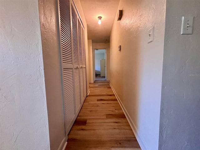 corridor with light hardwood / wood-style flooring