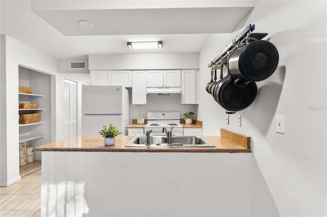 kitchen featuring white cabinets, white appliances, sink, and light tile patterned floors