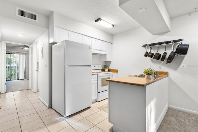 kitchen featuring white appliances, white cabinetry, ceiling fan, and light tile patterned flooring