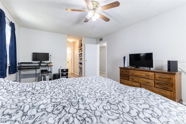 bedroom with ceiling fan and a textured ceiling