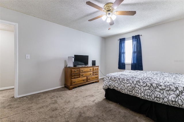 carpeted bedroom featuring ceiling fan and a textured ceiling