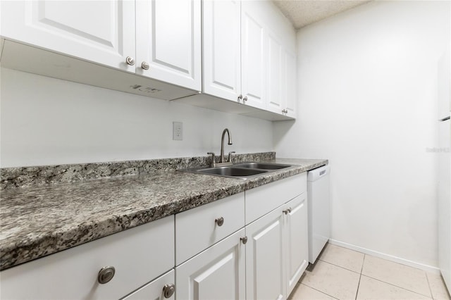 kitchen with white cabinets, sink, white dishwasher, light tile patterned floors, and a textured ceiling