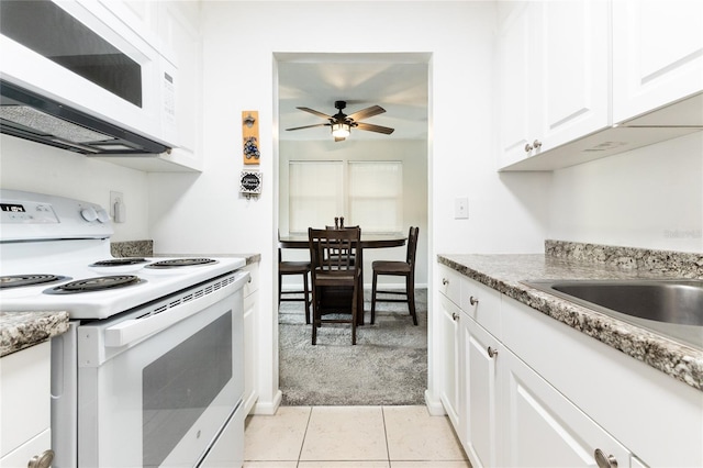 kitchen featuring ceiling fan, light tile patterned floors, white appliances, and white cabinetry