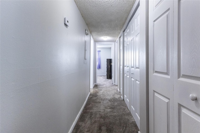 corridor featuring carpet and a textured ceiling