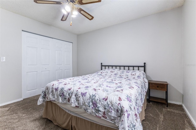 bedroom featuring ceiling fan, a closet, dark carpet, and a textured ceiling