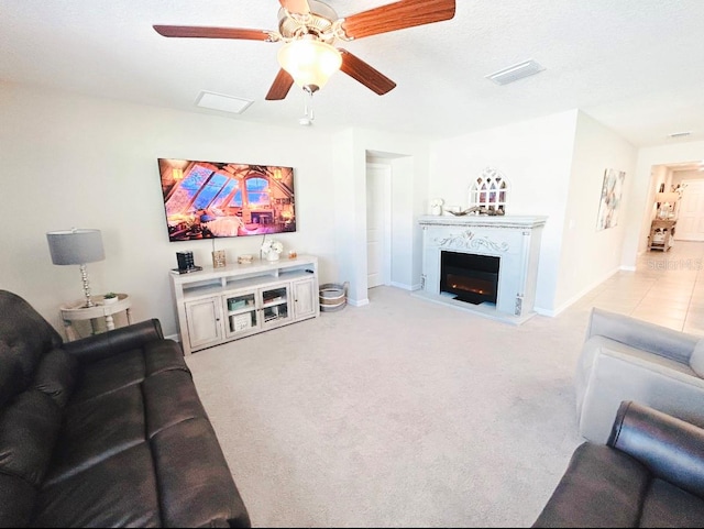 carpeted living room with a textured ceiling and ceiling fan