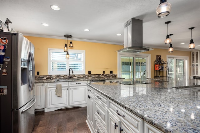 kitchen with white cabinets, island range hood, plenty of natural light, and stainless steel fridge