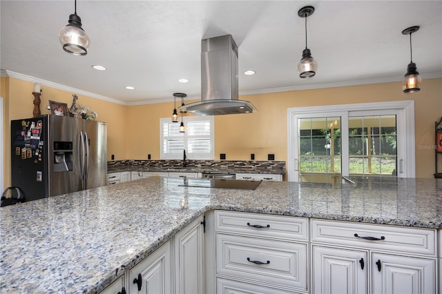 kitchen featuring stainless steel refrigerator with ice dispenser, white cabinets, island range hood, and a wealth of natural light