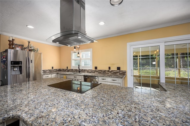 kitchen with island exhaust hood, appliances with stainless steel finishes, crown molding, and dark stone countertops