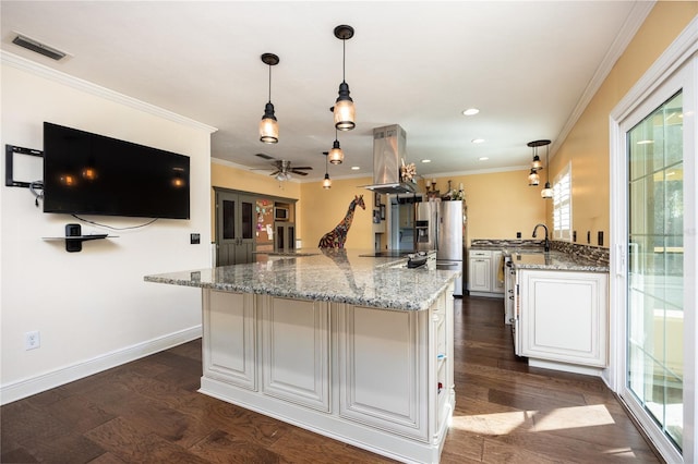 kitchen featuring hanging light fixtures, island exhaust hood, white cabinetry, and light stone counters