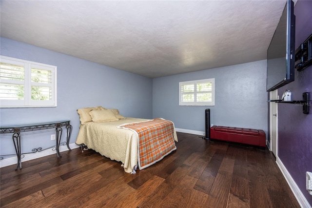 bedroom featuring a textured ceiling and dark hardwood / wood-style floors