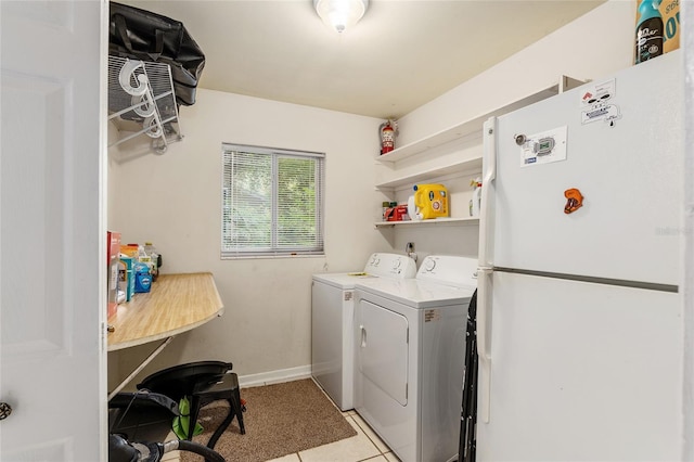 washroom with light tile patterned floors and washing machine and dryer