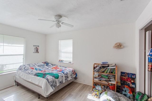 bedroom with light hardwood / wood-style floors and ceiling fan